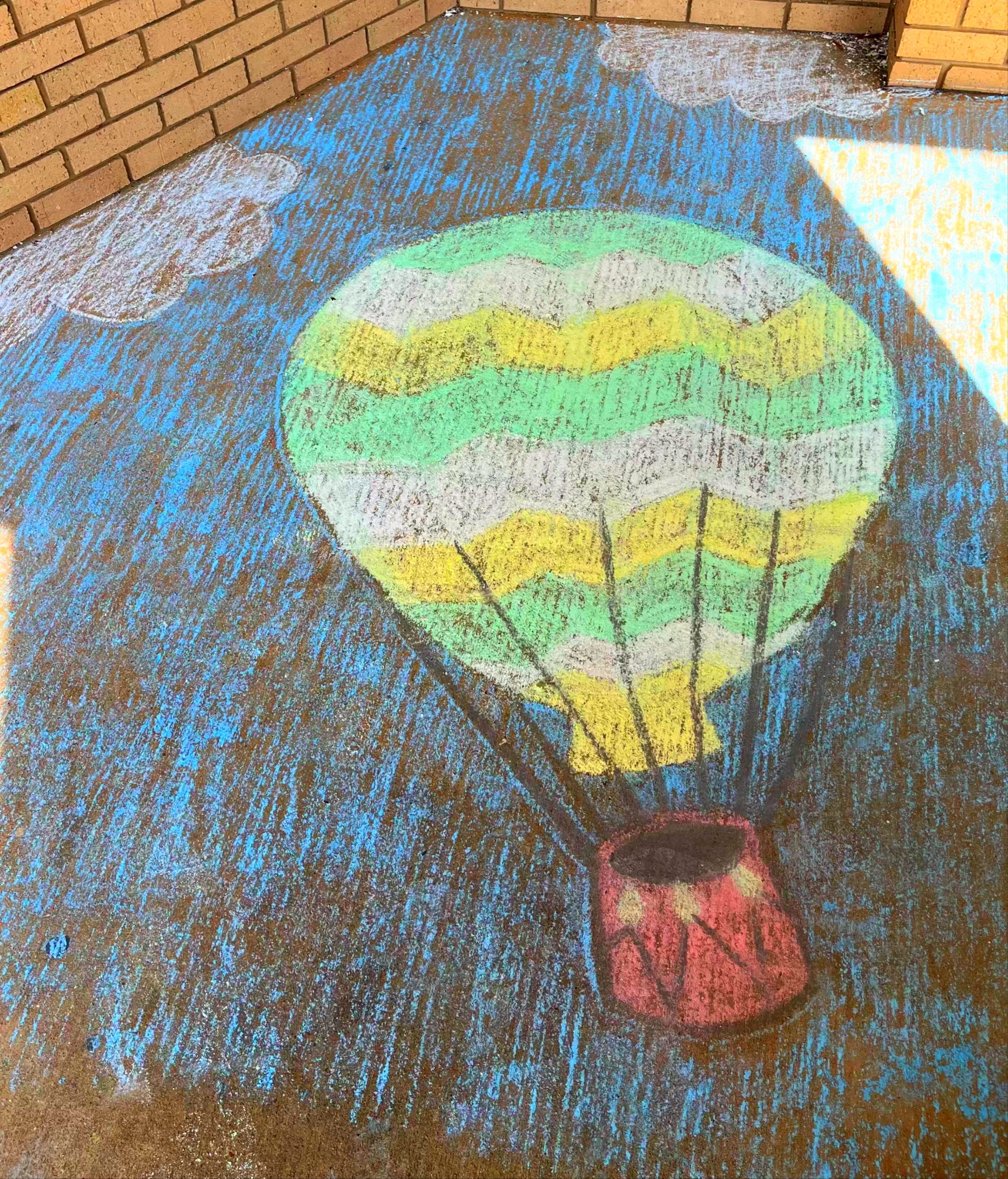 Kids drawing with chalk on pavement at summer outdoor community festival
